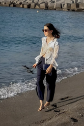 a lady in a map printed silk shirt and a pair of black pants